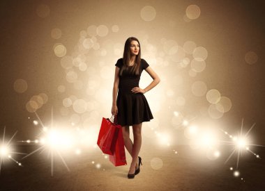 Parlak ışıklarda çantalı alışveriş yapan kadın.