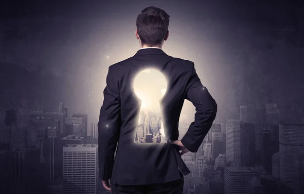Businessman standing with keyhole on his back