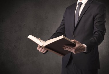 Elinde kitap tutan bir işadamı.