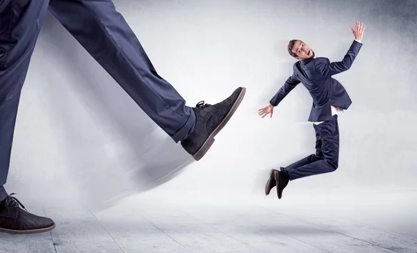 Grande perna chutando pequeno homem — Fotografia de Stock