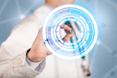 Erkek doktor elinde parlak halkaları olan bir hap tutuyor.