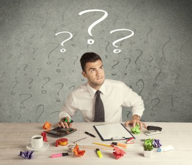 İş adamı soru işaretiyle masada.