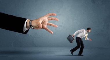 İş adamı büyük bir el kavramından kaçıyor.