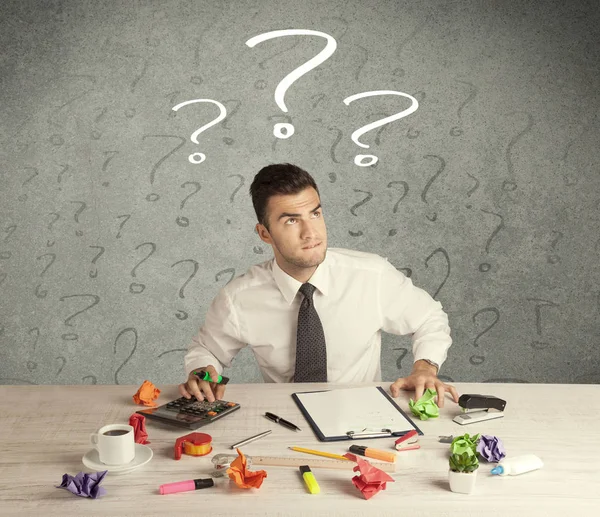 İş adamı soru işaretiyle masada.