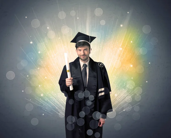 Happy graduate met kleurrijke moeras lichten op de achtergrond — Stockfoto