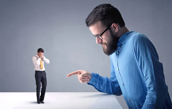 Joven hombre de negocios luchando con empresario en miniatura — Foto de Stock