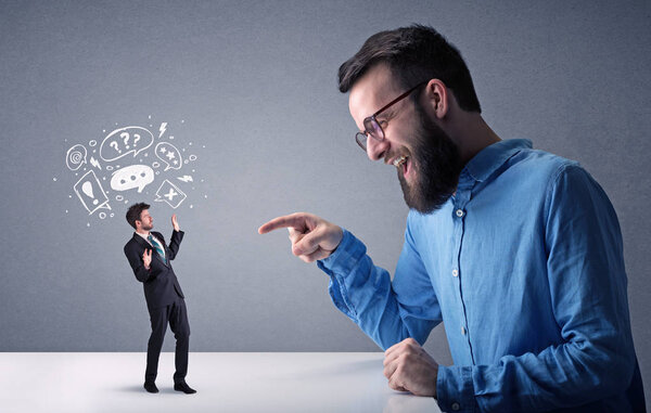 Young businessman fighting with miniature businessman