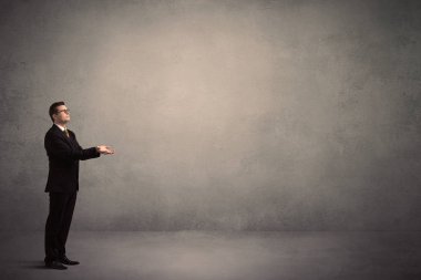 Boş bir duvarın önünde, ayakta işadamı