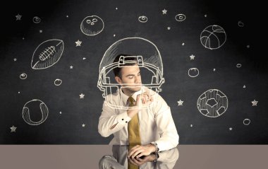 İş adamı miğfer ve spor topu çiziyor.