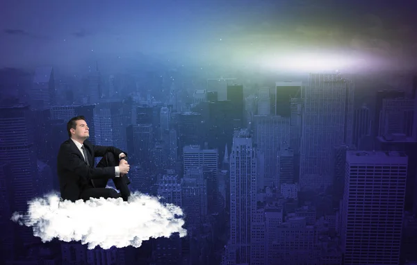 Man sitting on a cloud above the city — Stock Photo, Image