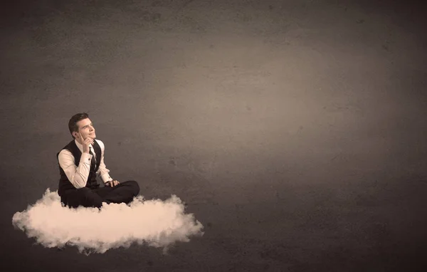 無地の背景で雲の上に座っている男 — ストック写真
