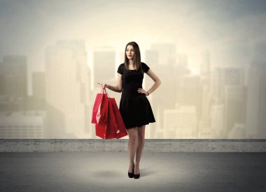 Alışveriş torbalarıyla duran şehir kadını.