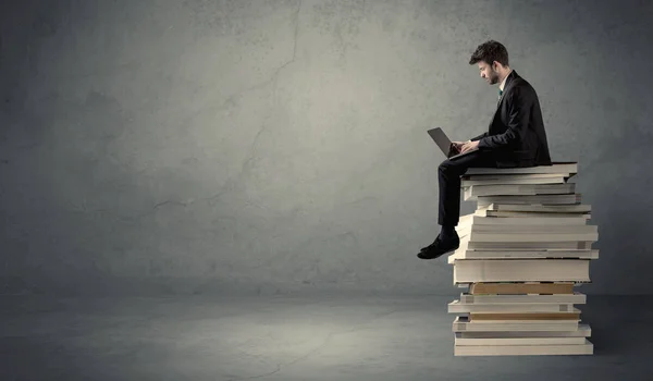 Étudiant assis sur une pile de livres — Photo