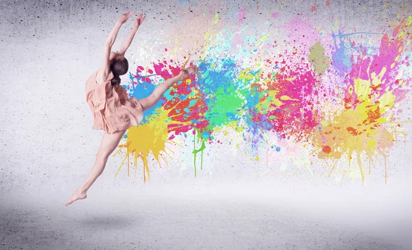 Modern street dancer jumping with colorful paint splashes — Stock Photo, Image