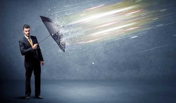 Homme d'affaires défendant les faisceaux lumineux avec concept de parapluie — Photo