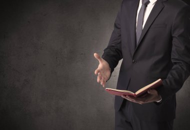 Elinde kitap tutan bir işadamı.