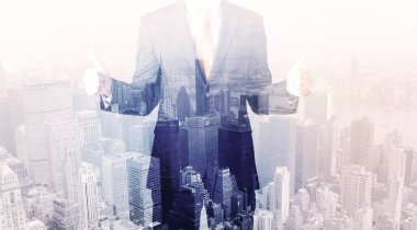 İş adamı çatıda duruyor ve arka planda şehir var.