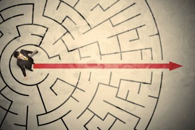 Dairesel bir labirent ortasında duran iş kişi