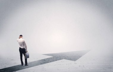 Ayakta duran satıcı elinde okla ileriye bakıyor.