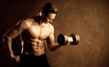 Kas formundaki vücut geliştirici sporcu ağırlık kaldırıyor 