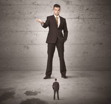 Büyük bir iş adamı küçük bir iş arkadaşına bakıyor.