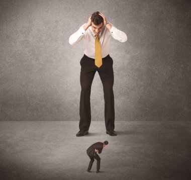 Büyük iş adamı küçük işçilere bakıyor.