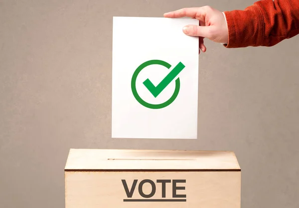 Fechar a mão masculina colocando voto em uma urna — Fotografia de Stock