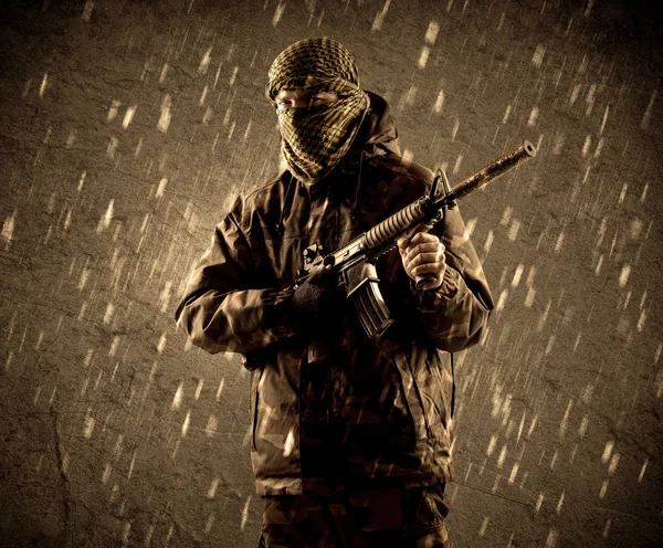Gevaarlijke zwaar bewapende terroristische soldaat met masker op grungy ra — Stockfoto