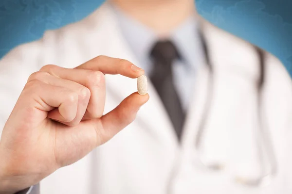 Doctor en blanco sosteniendo una píldora — Foto de Stock