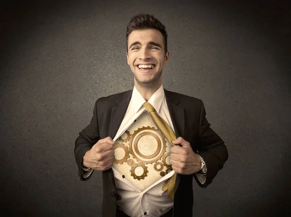 Businessman tearing shirt off and machine cog wheel shows