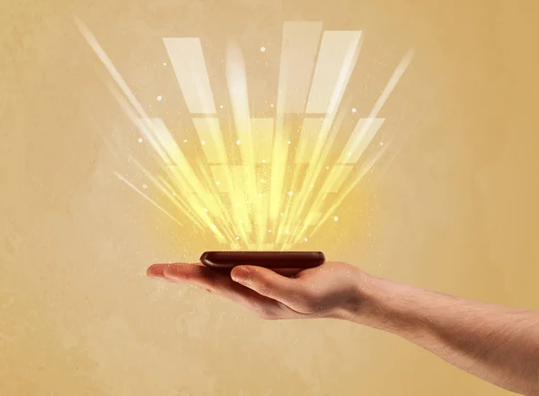 Hand with telephone and yellow light — Stock Photo, Image