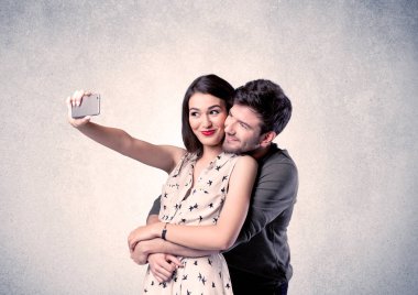 Mutlu çift temiz duvarlı selfie çekiyor.