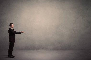 Boş bir duvarın önünde, ayakta işadamı