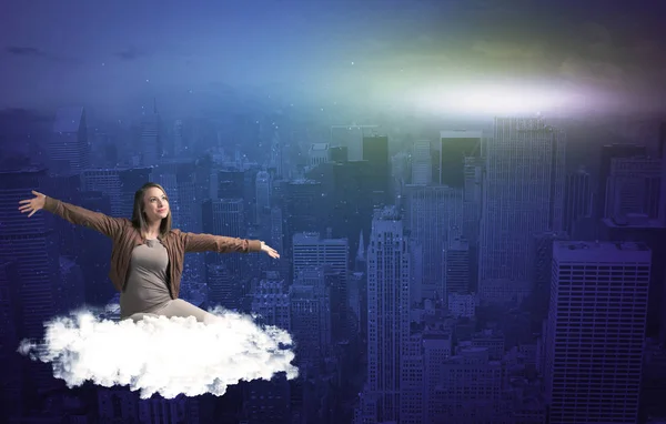 Woman sitting on cloud above the city — Stock Photo, Image