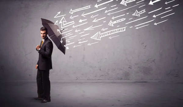 Geschäftsmann mit Regenschirm und gezückten Pfeilen, die ihn treffen — Stockfoto