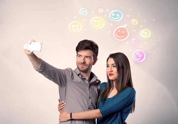 Pareja feliz tomando selfie con smiley —  Fotos de Stock