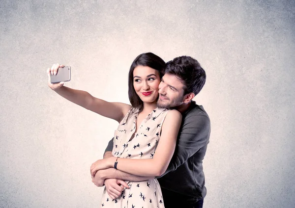 Felice coppia prendendo selfie con parete chiara — Foto Stock