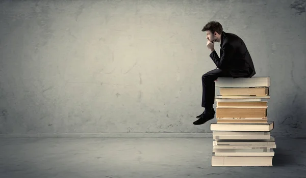 Student sitting on stack of books — Stock Photo, Image