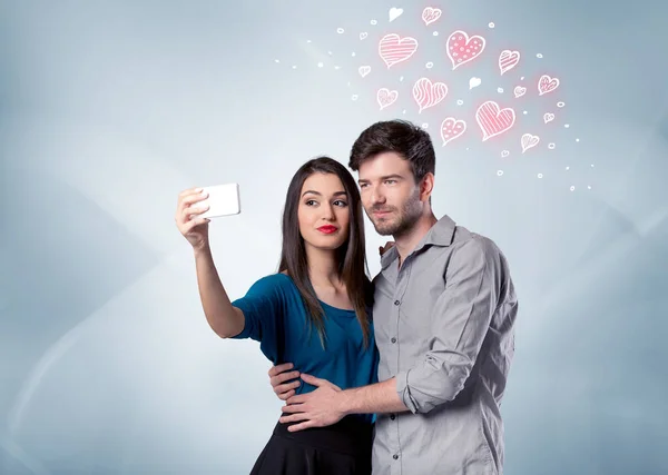 Casal apaixonado tomando selfie com coração vermelho — Fotografia de Stock
