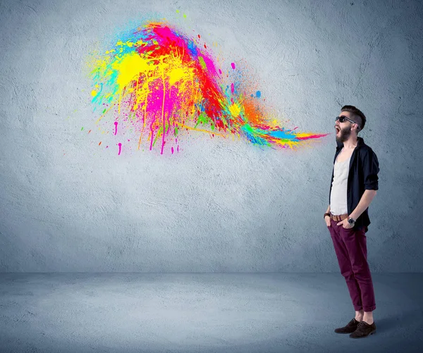 Hipster kerel schreeuwen kleurrijke verf op de muur — Stockfoto