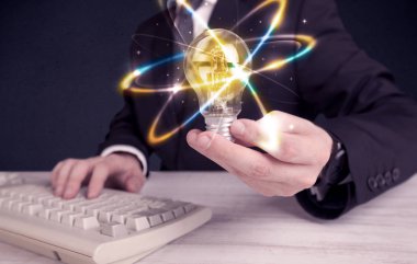 renkli bir ampul tutan işadamı