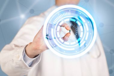 Erkek doktor elinde parlak halkaları olan bir hap tutuyor.