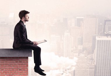 Şehirde çatıda oturan ofis çalışanı