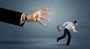 İş adamı büyük bir el kavramından kaçıyor.