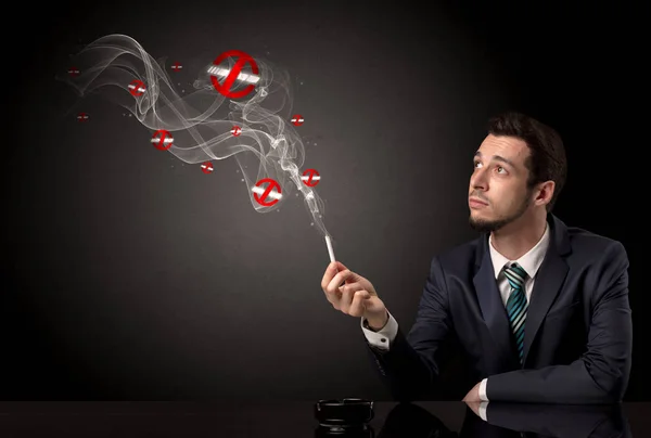 Businessman smoking in a dark room — Stock Photo, Image