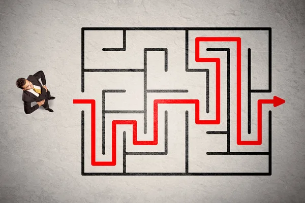 Homme d'affaires perdu trouvé le chemin dans le labyrinthe avec flèche rouge — Photo