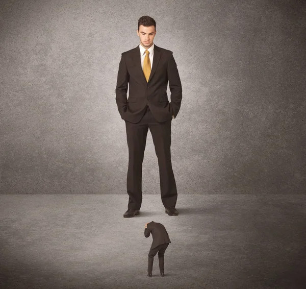 Gran hombre de negocios mirando a un pequeño trabajador — Foto de Stock