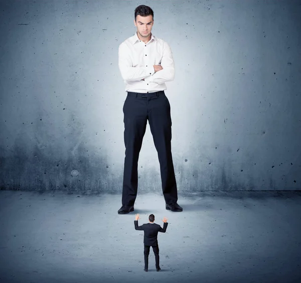 Öfkeli büyük iş adamı küçük adama lokma atıyor.