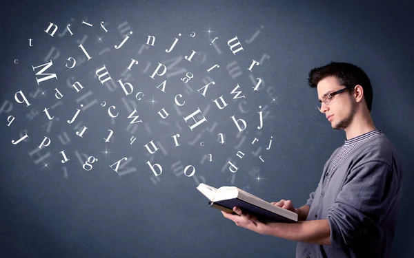 Jovem segurando livro com letras — Fotografia de Stock