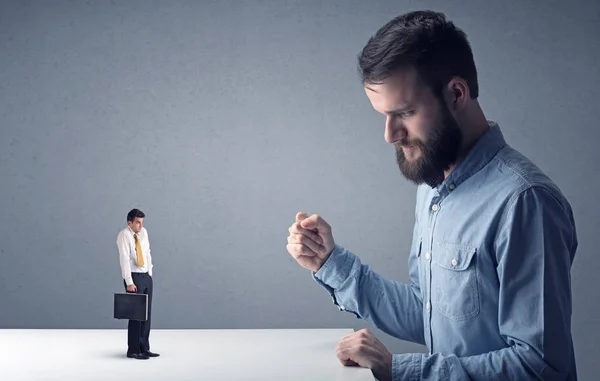 Joven hombre de negocios luchando con empresario en miniatura — Foto de Stock